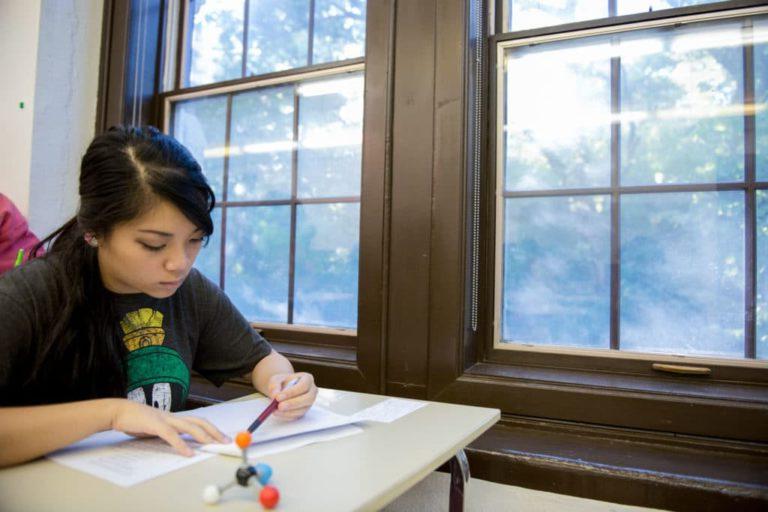 student at desk by window